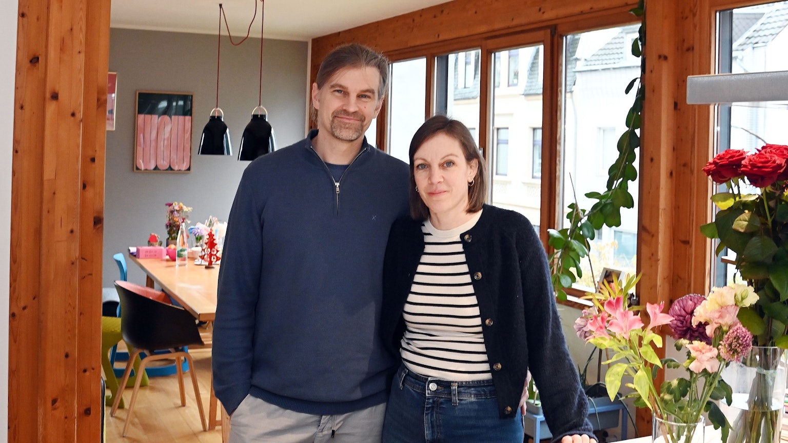 Die Eltern, Julischka und Sebastian stehen am Küchentisch und schauen in die Kamera.