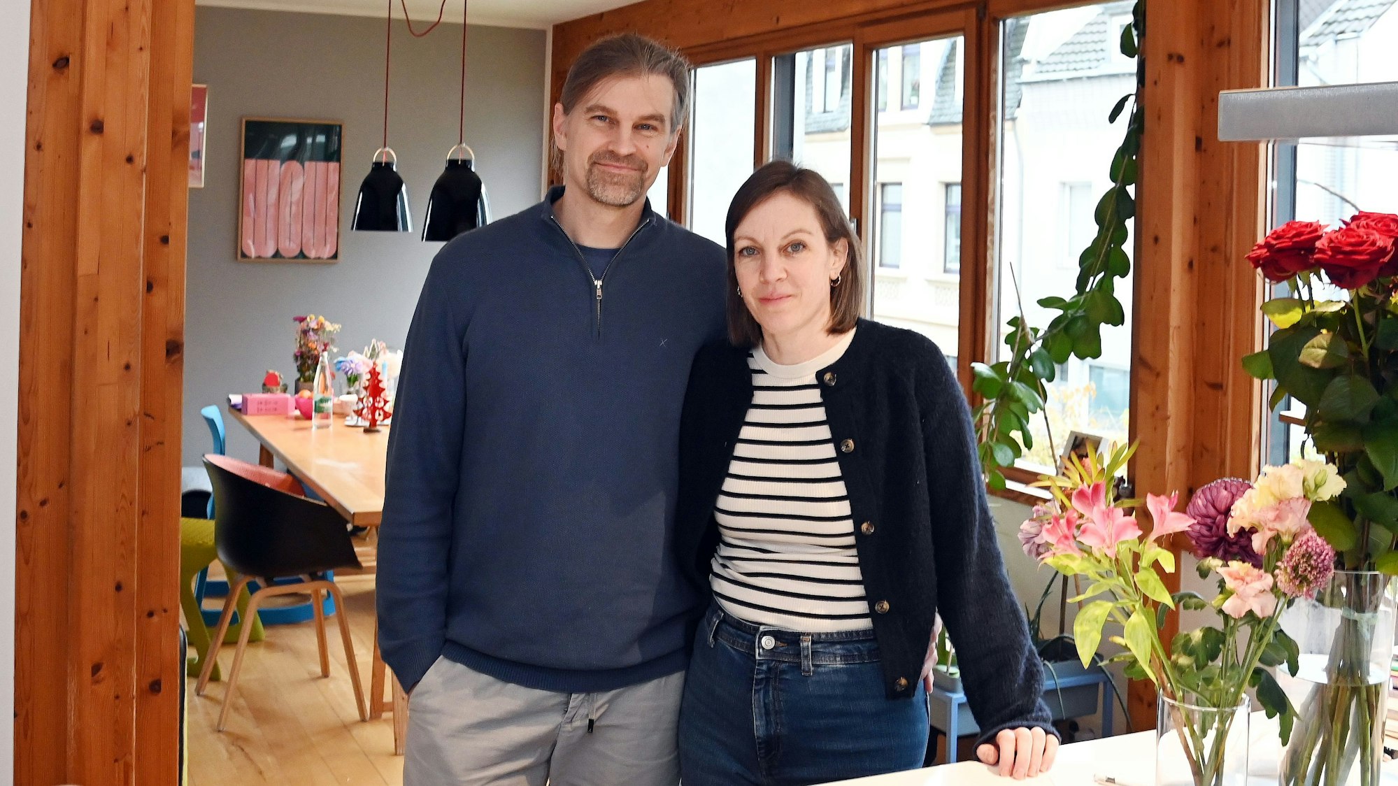 Die Eltern, Julischka und Sebastian stehen am Küchentisch und schauen in die Kamera.