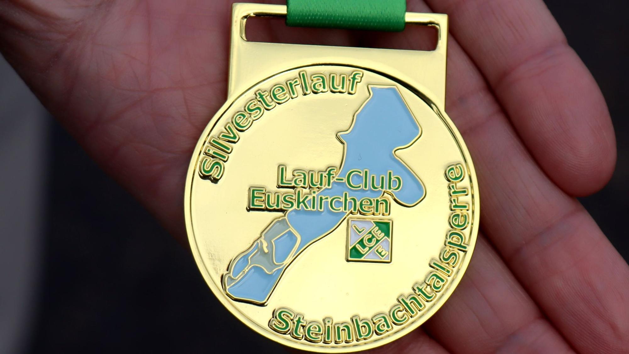 Die neue Medaille des Silvesterlaufs zeigt neben dem Logo des LC Euskirchen auch die Steinbachtalsperre, die blau gefüllt ist.
