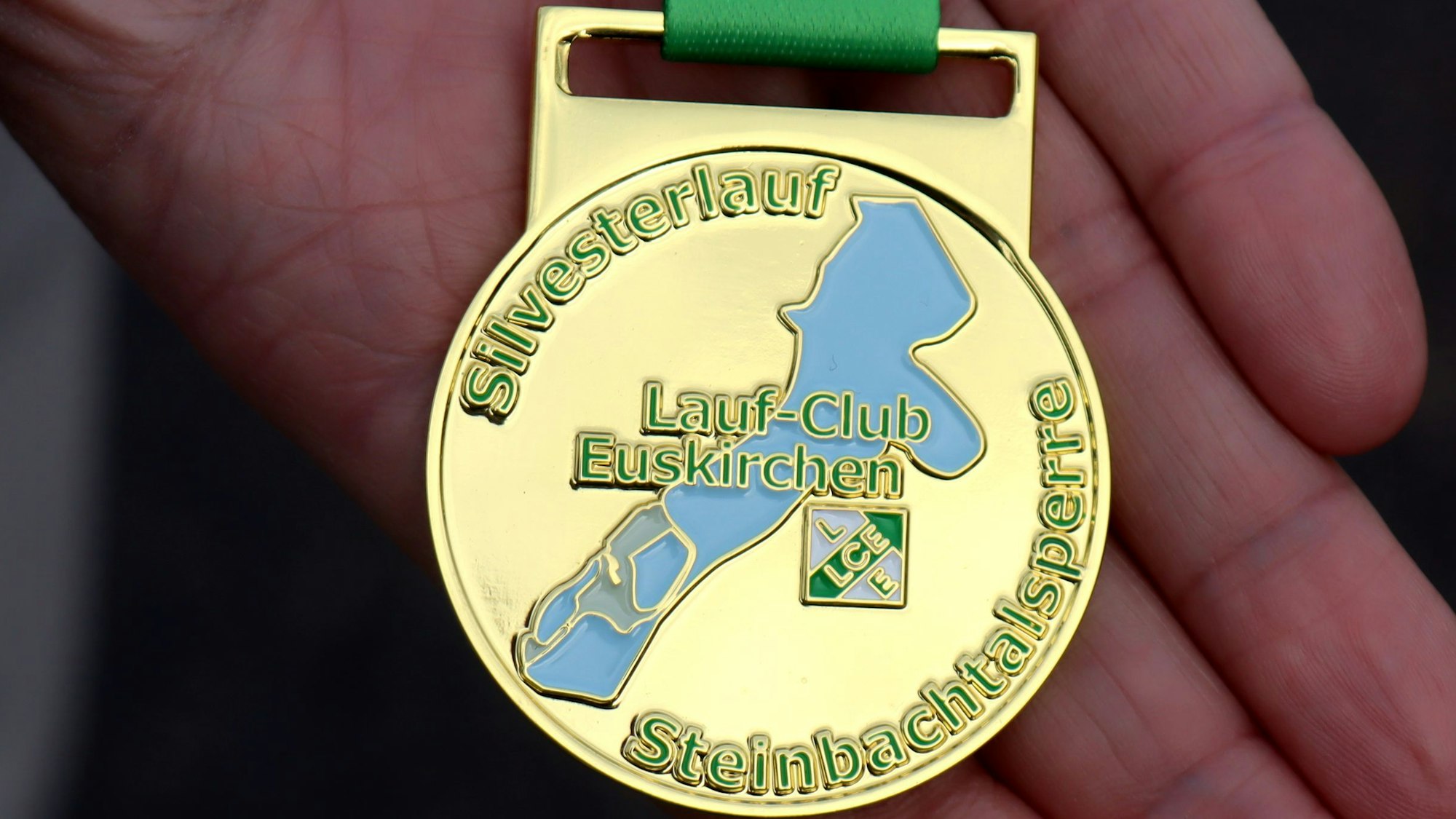 Die neue Medaille des Silvesterlaufs zeigt neben dem Logo des LC Euskirchen auch die Steinbachtalsperre, die blau gefüllt ist.