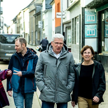 Das Bild zeigt Vertreter der Stadt Euskirchen, von Feder und Anwohner, die die Bischofstraße entlang gehen.