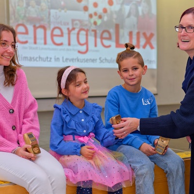 Alina von der Realschule am Stadtpark, Sophie von der Kita Heinrich-Lübke-Straße und Louis von der Hans-Christian -Andersen Schule erhalten das „goldene Energiesparmessgerät“ von Bezirksbürgermeisterin Michaela Di Padova.