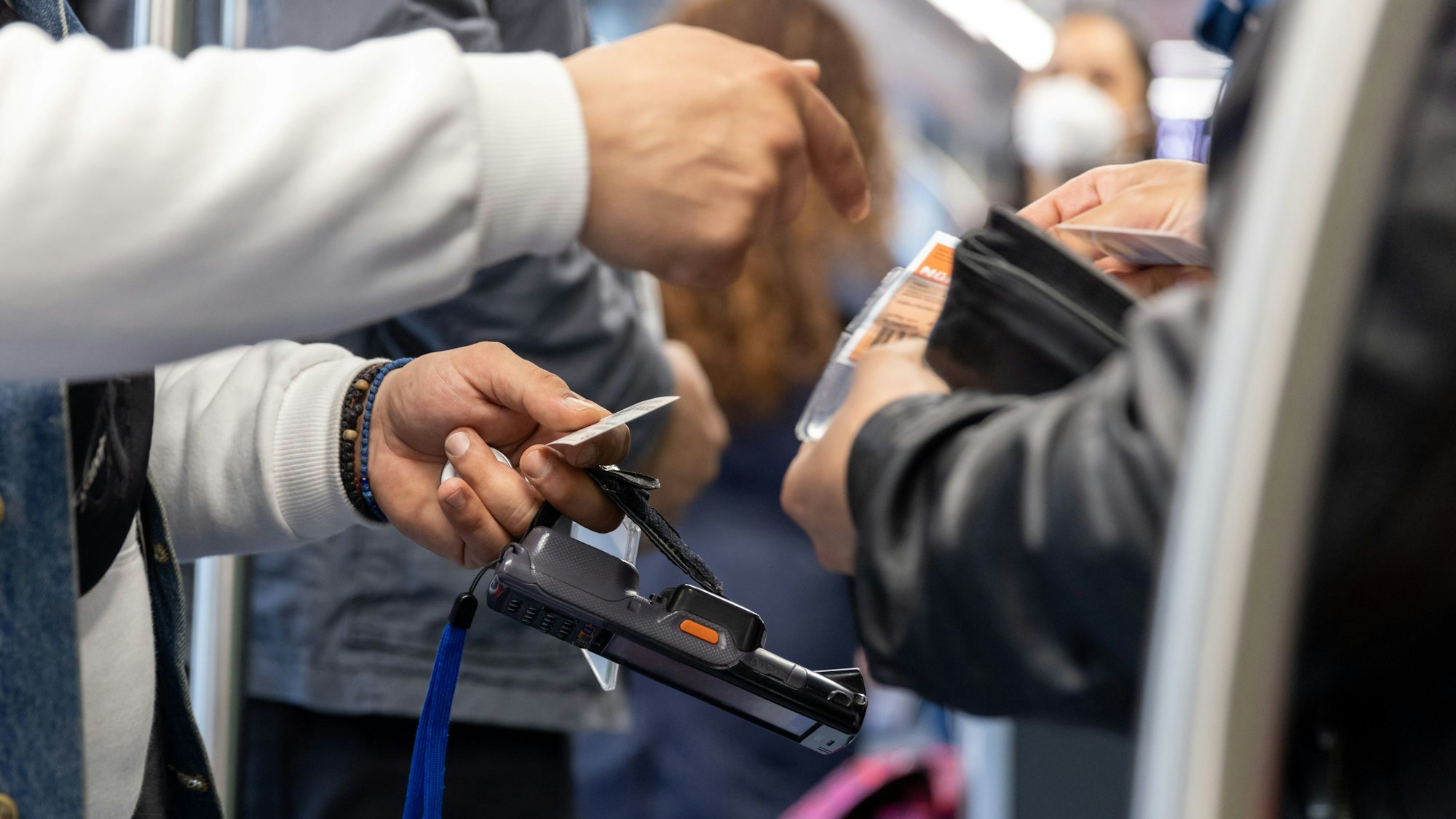 Ein Fahrkartenkontrolleur überprüft den Fahrschein eines Reisenden.
