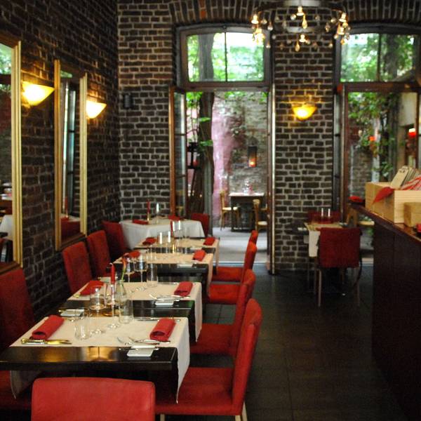 Das Restaurant Limbourg in der Limburger Straße im belgischen Viertel
von innen mit Theke, roten Stühlen und gedeckten Tischen.