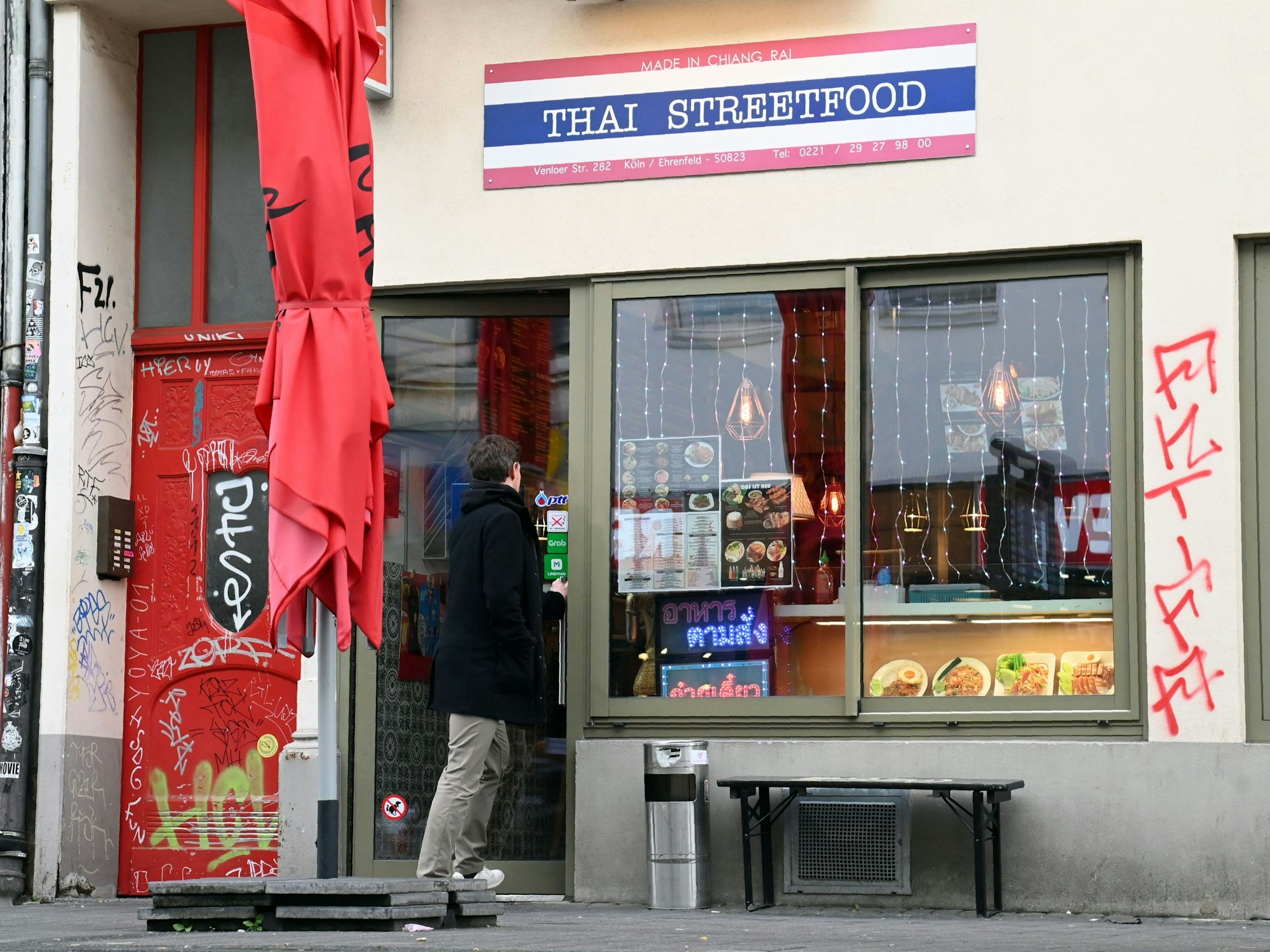 Eingang und Fassade des Lokals sind zu sehen. Ein Mann ist im Begriff, einzutreten.