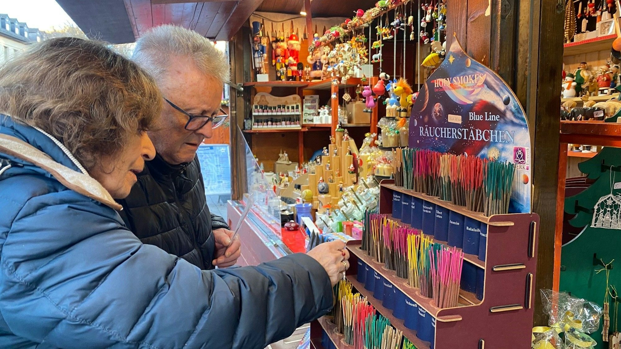 Zu sehen sind eine Frau und ein Mann, die bunte Räucherstäbchen betrachten.