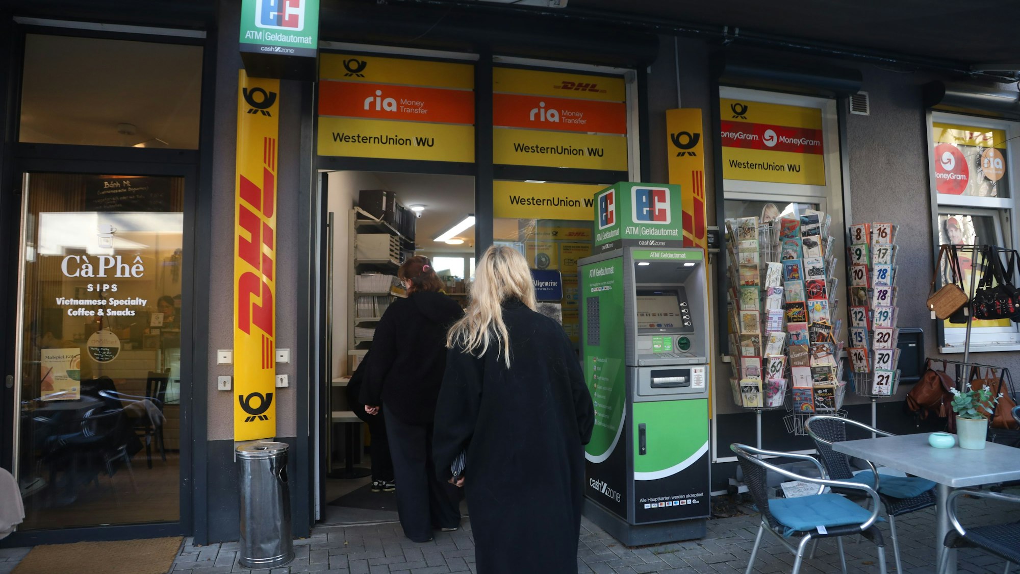 Mehrere Personen stehen vor einer DHL-Filiale in Nippes.