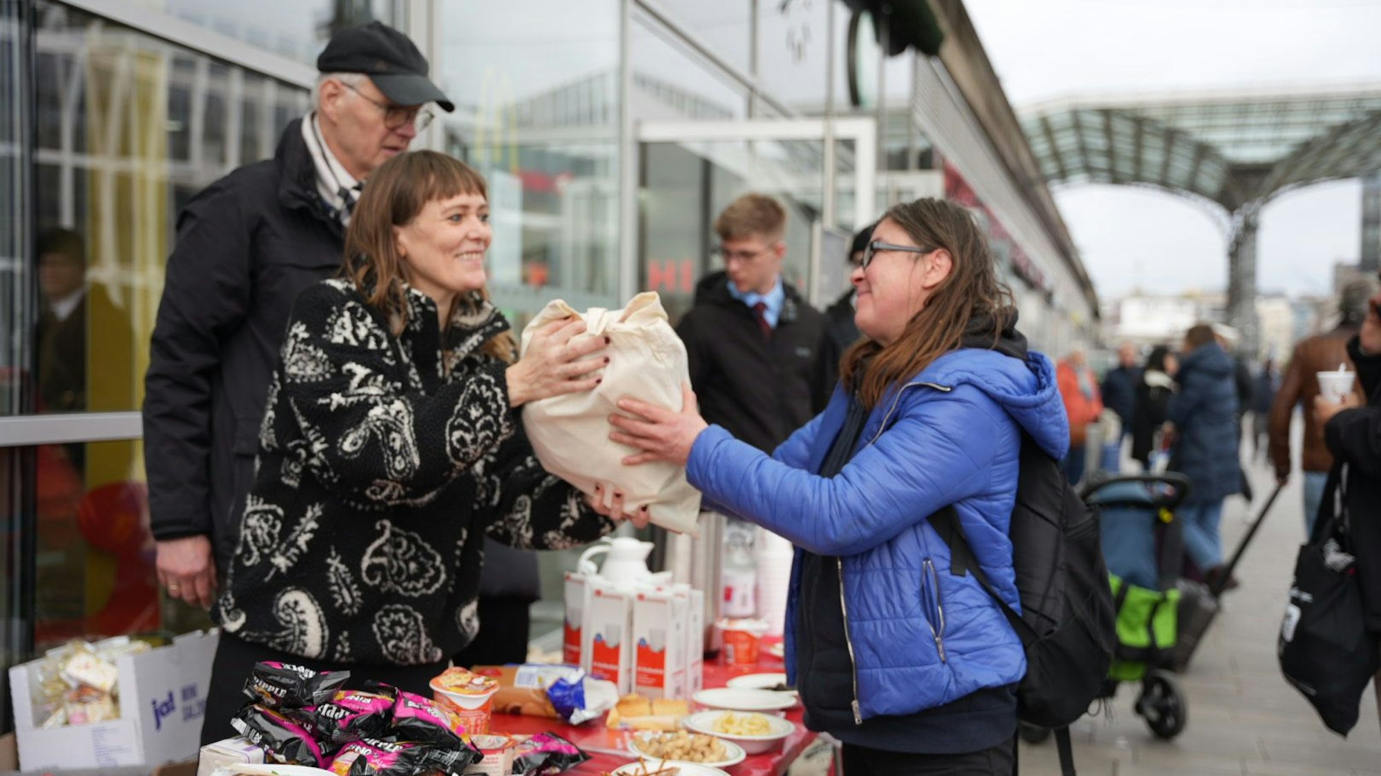 Eine Frau überreicht einer anderen Frau einen Beutel.