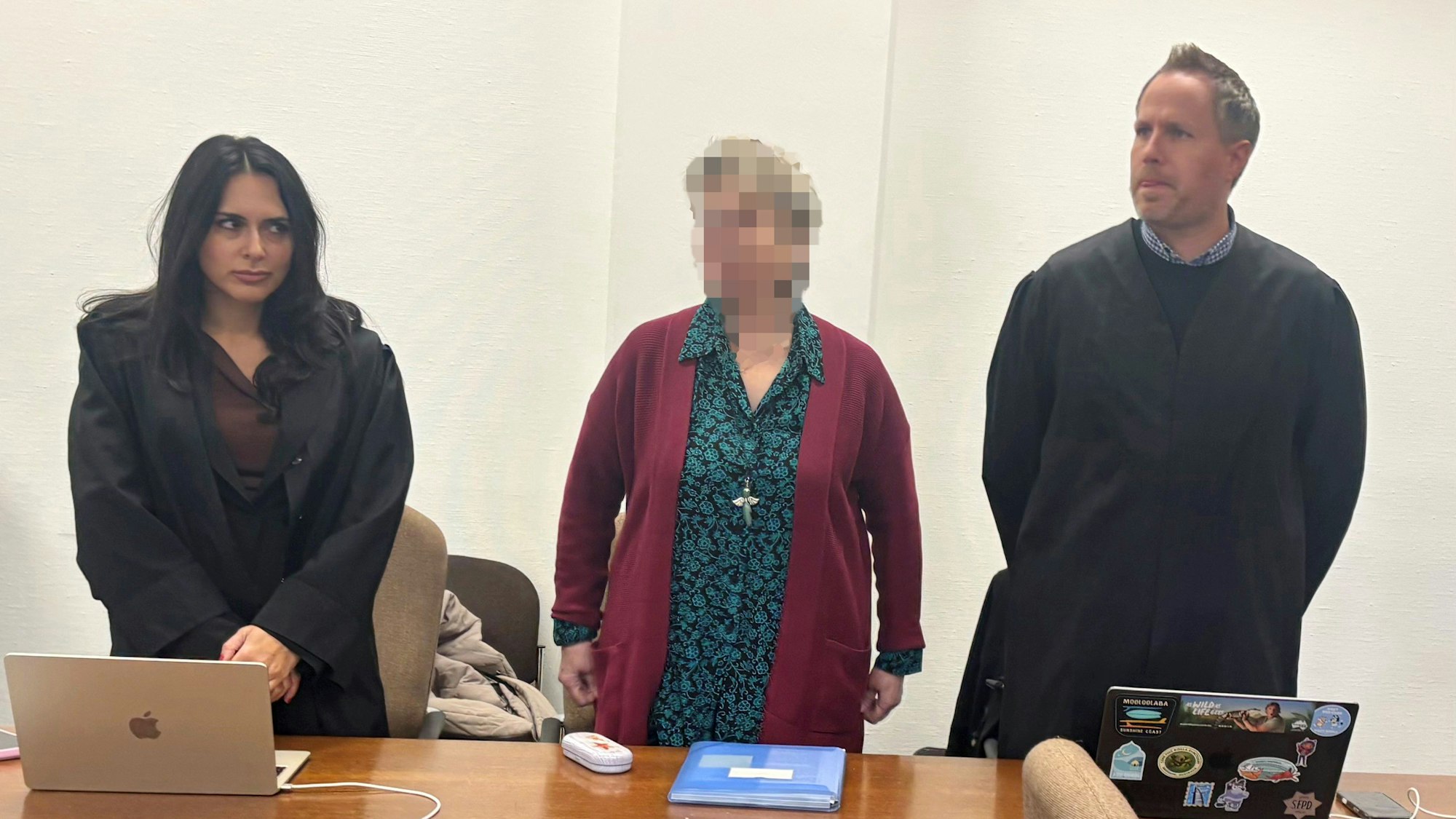 Die angeklagte Witwe steht mit ihrer Verteidigung vor Gericht.