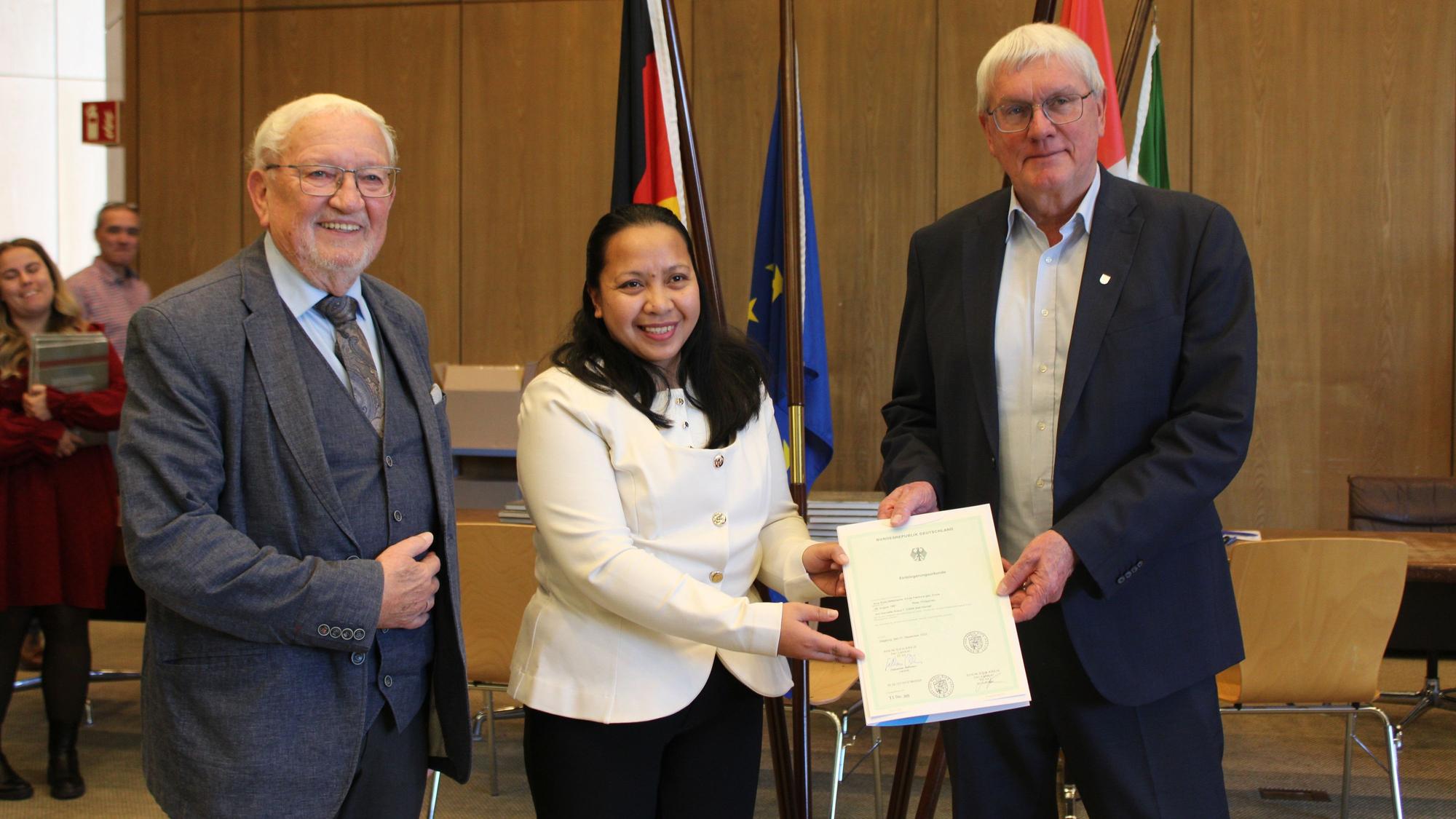 Amy Rose Pabilona, aufgewachsen auf den Philippinen, wurde am 11.12.25 eingebürgert, mit Landrat Sebastian Schuster und dem Neubürgerbeauftragten Ludwig Neuber.