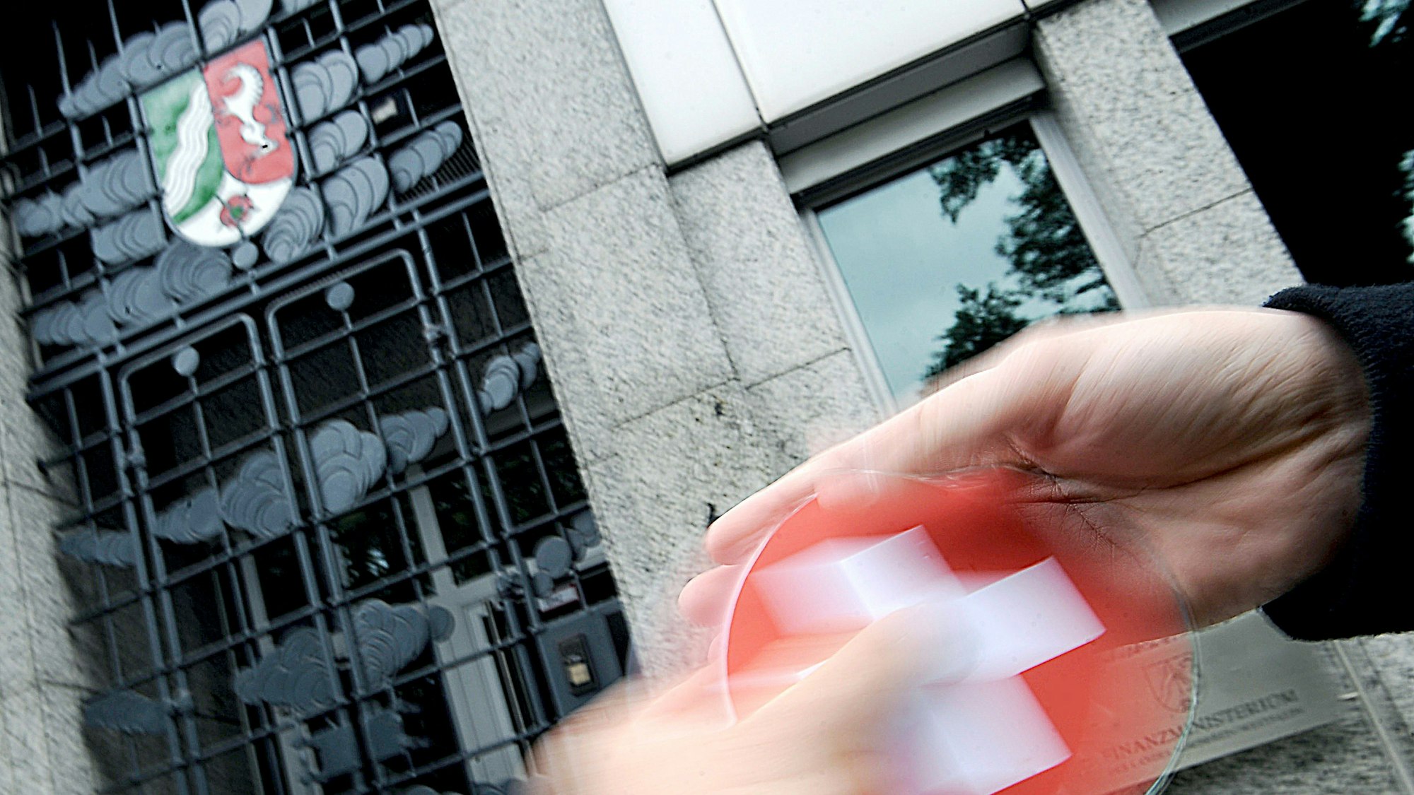 IGestellte Szene: Eine Hand übergibt vor dem Finanzministerium in Düsseldorf eine CD mit den Daten von Steiersündern