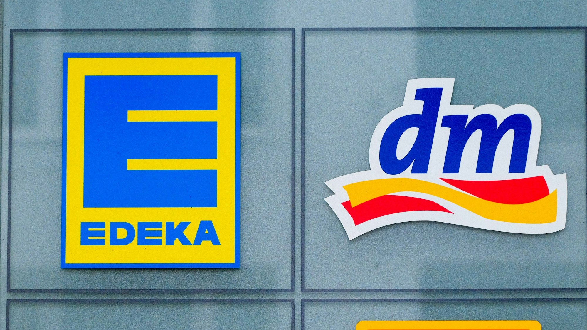 Logos von Edeka und dm.