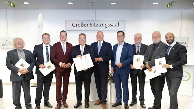 Zu sehen ist eine Gruppe von Männern mit Urkunden.