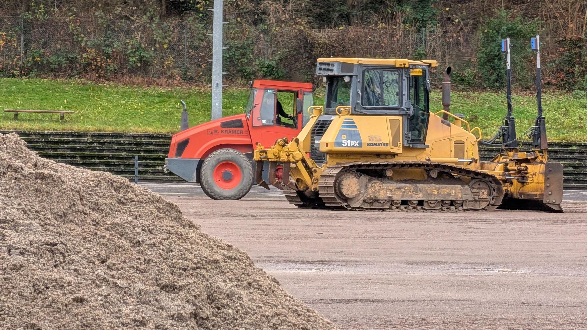 Das Foto zeigt Bagger und einen Sandhaufen auf dem Sportplatz in Berrenrath.