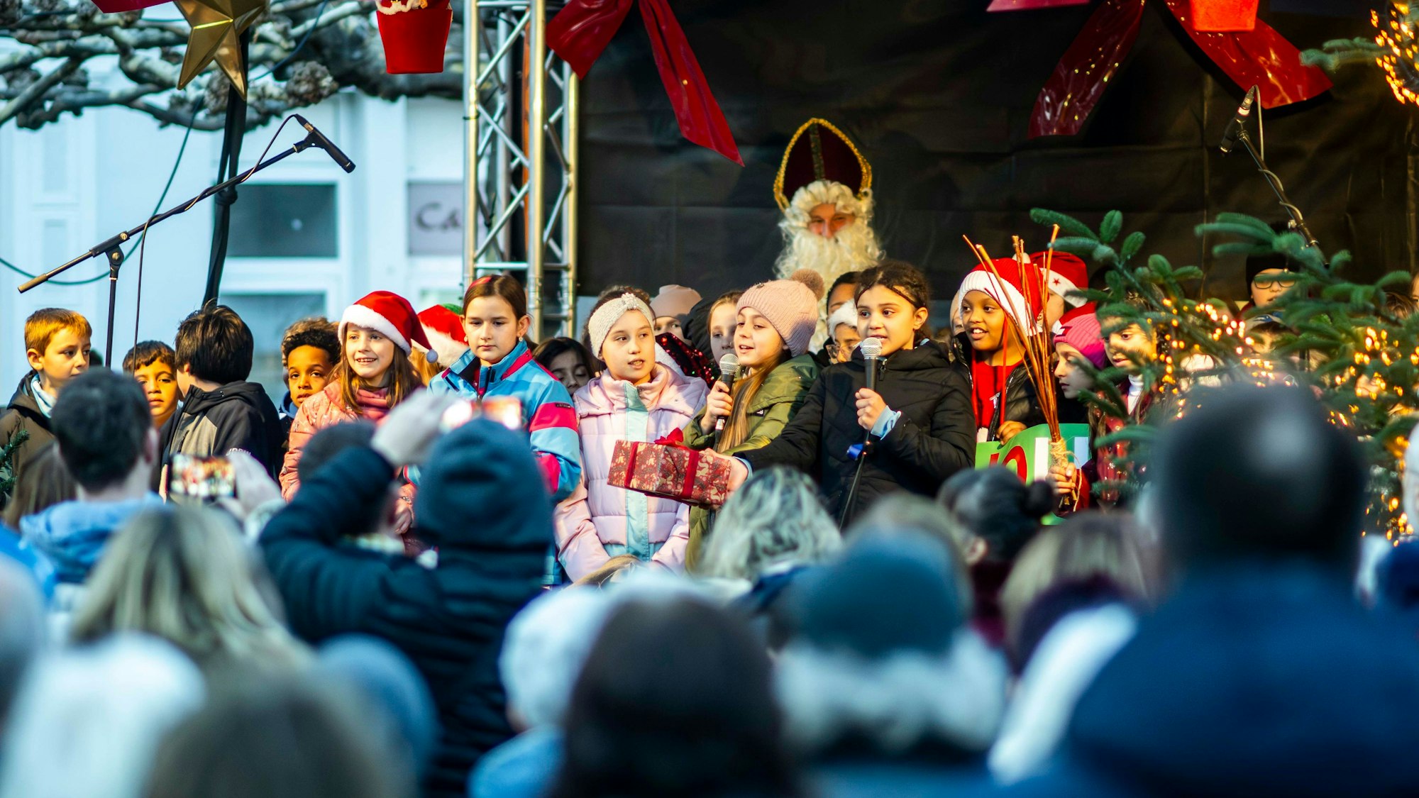Kinder eines Chores beim Auftritt auf der Weihnachtsmarktbühne.