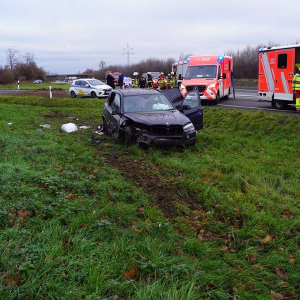 Der verunglückte Wagen steht auf dem Grünstreifen. Auf der Autobahn stehen die Fahrzeuge des Rettungsdienstes.