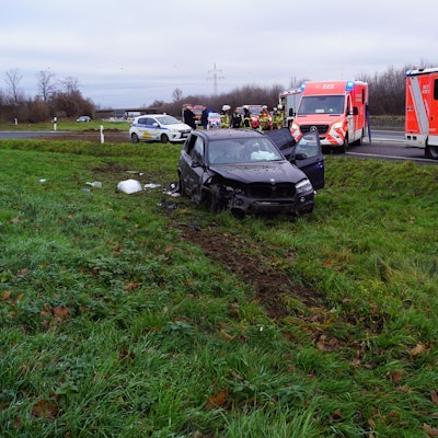 Der verunglückte Wagen steht auf dem Grünstreifen. Auf der Autobahn stehen die Fahrzeuge des Rettungsdienstes.