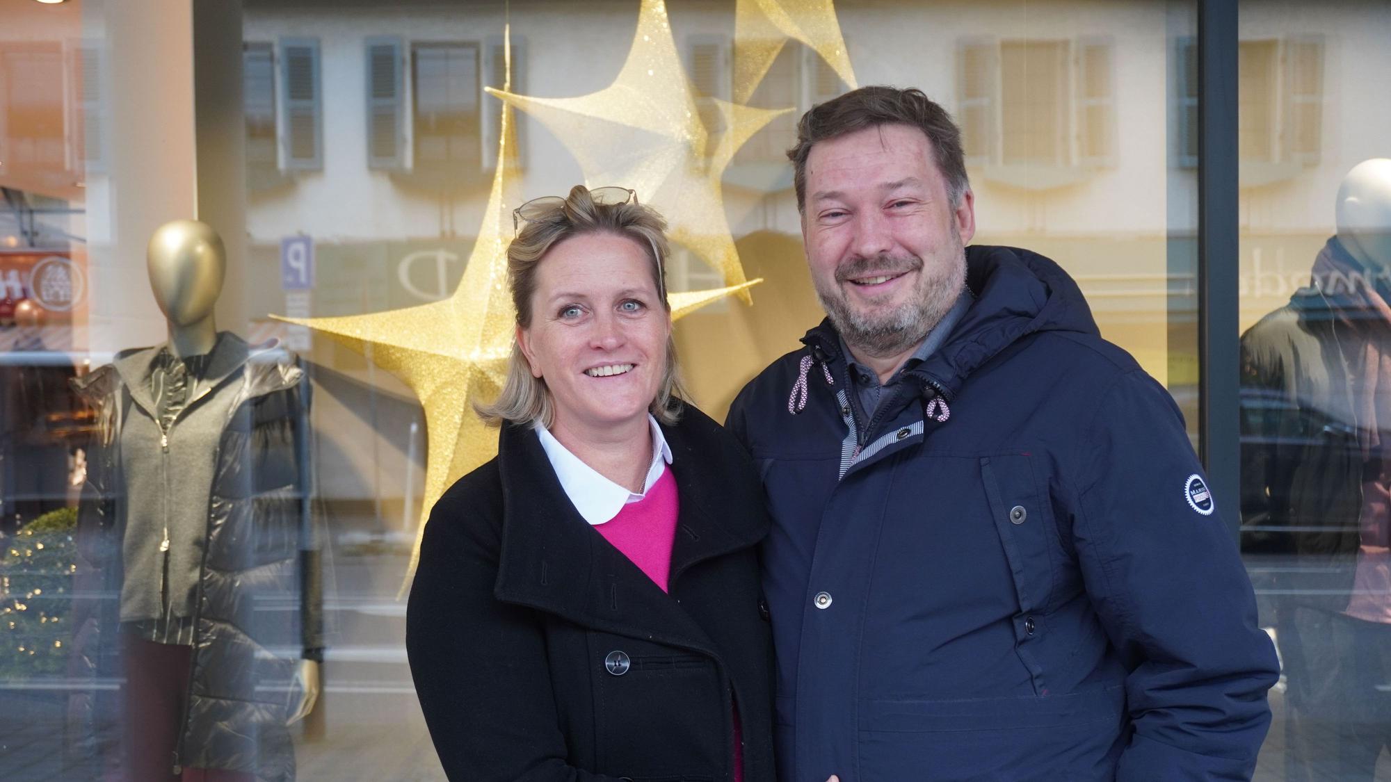 Das Foto zeigt das Paar vor dem Schaufenster eines Geschäfts.