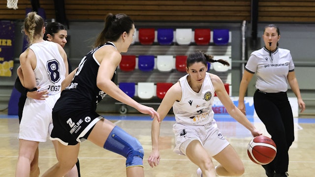 Das Foto zeigt eine Basketballspielerin des Hürther BC mit Ball, die ihre Gegenspielerin um kurven möchte.