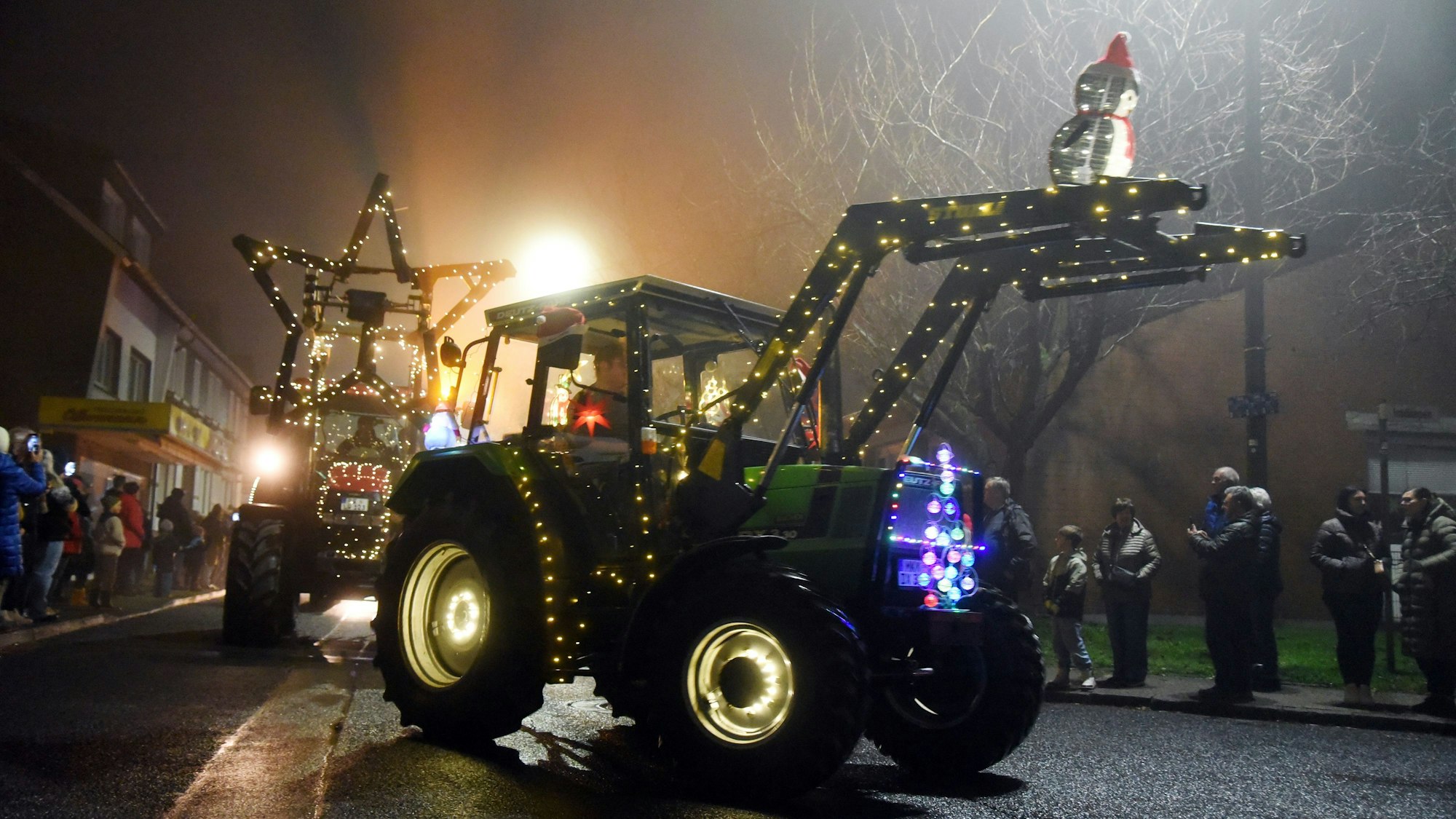 Das Foto zeigt bunt beleuchtete Traktoren