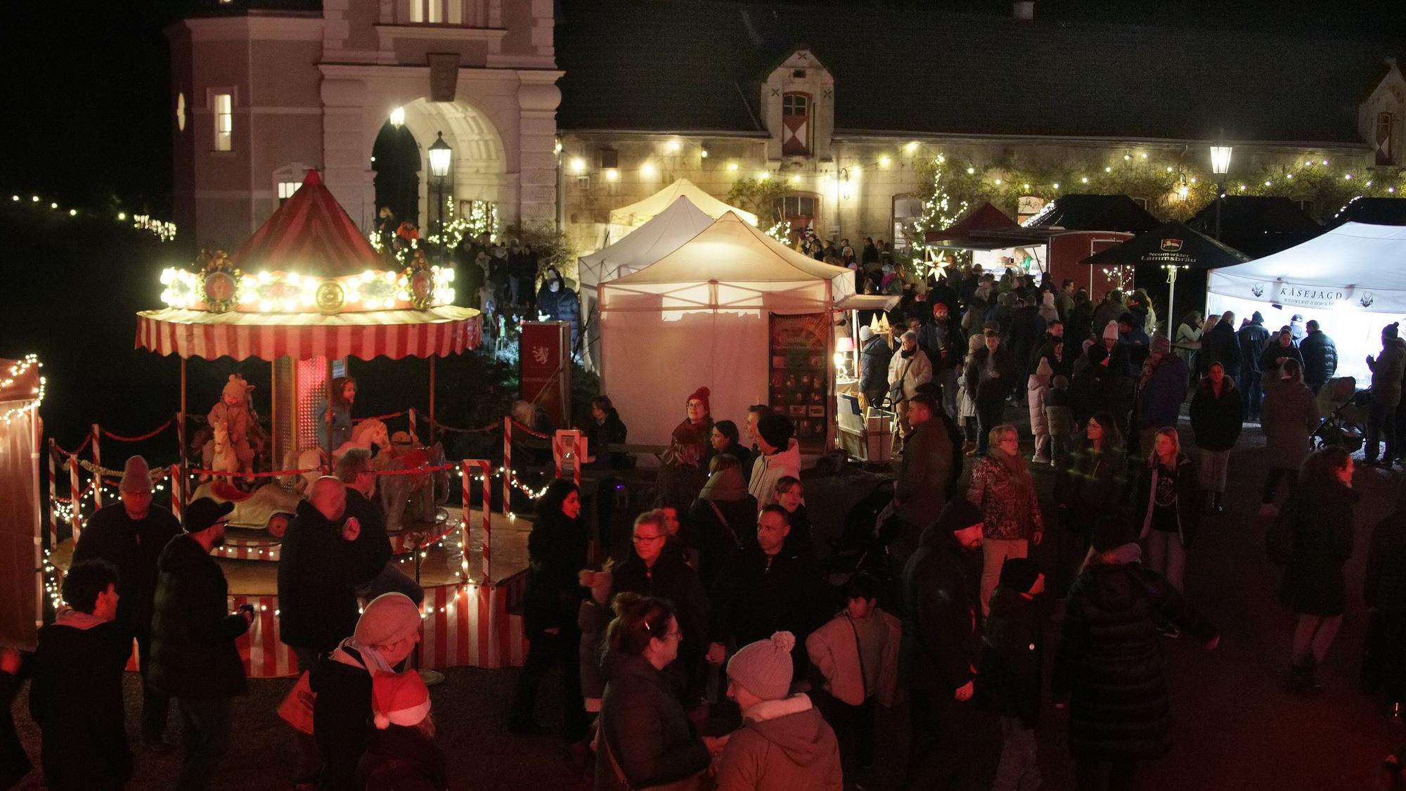 Das Foto zeigt Menschen auf einem Weihnachtsmarkt.