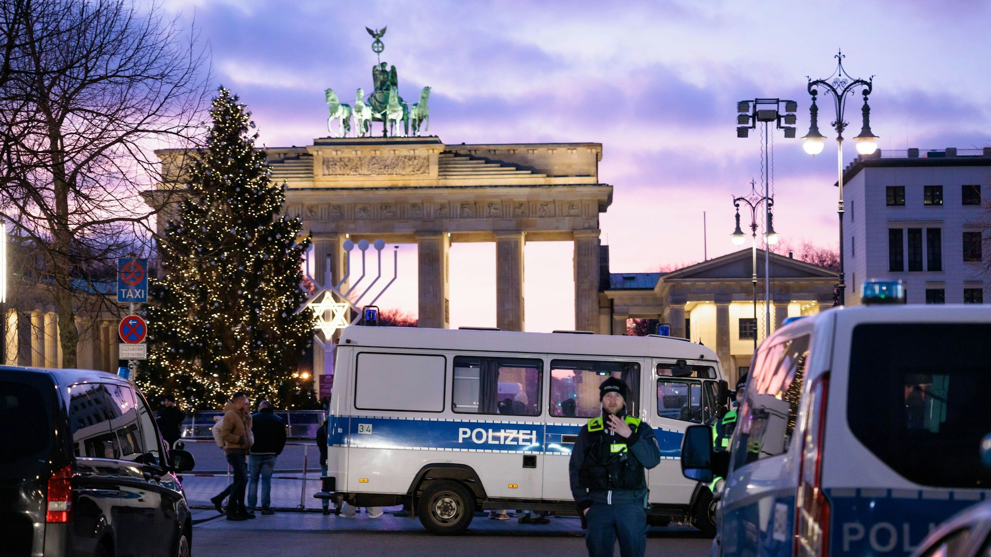 Polizisten stehen hinter Absperrgittern in der Nähe des Brandenburger Tors.