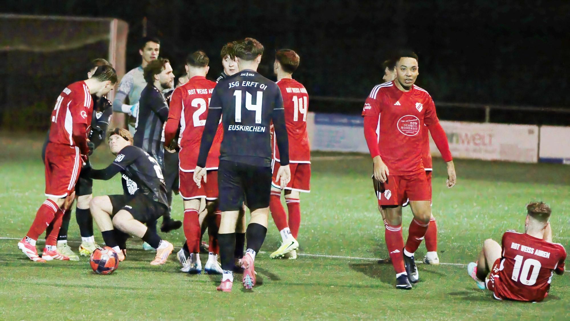 Fußballspieler stehen sich in einer Rudelbildung gegenüber. In der Mitte steht ein Spieler von Erft wieder auf, ganz rechts sitzt ein Ahremer Spieler auf dem Boden.14.12.25.JSG Erft 01 - RW Ahrem 2:3..In der Schlussphase der Partie gab es noch eine Rudelbildung.