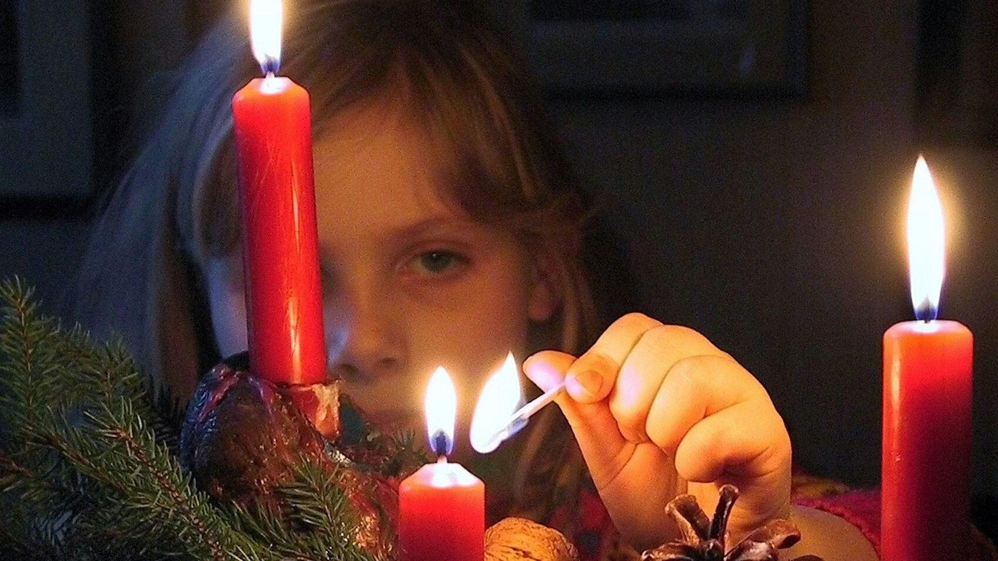 Mit einem Steichholz entzündet Franziska am Sonntag (17.12.2000) in Berlin die dritte Kerze auf ihrem Adventsgesteck.
