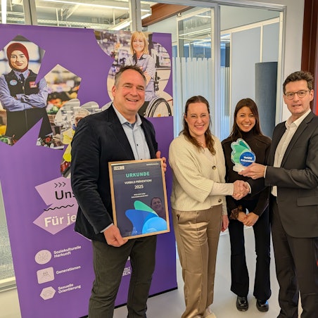 Das Foto zeigt die Verleihung von Preis und Urkunde in der Zentale von Rewe West in Hürth.