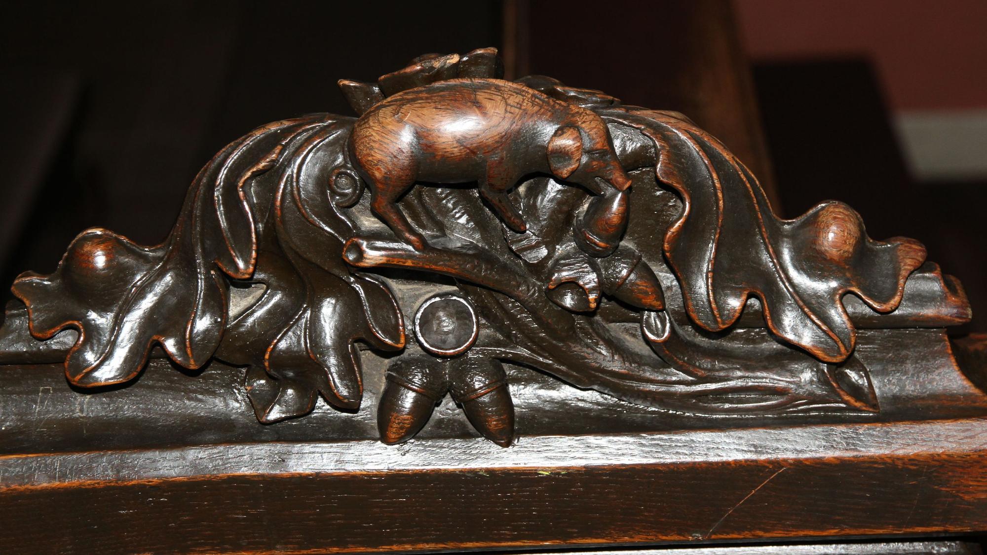 Weihnachtliche Motive in der Schatzkammer St. Servatius, Verfressenes Schwein auf dem Wangenkopf einer Kirchenbank