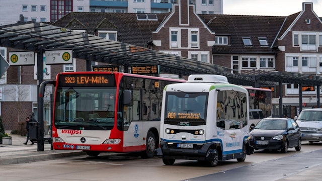 Zu sehen ist ein autonom fahrenden Linienbus in Monheim neben einem regulären Linienbus.