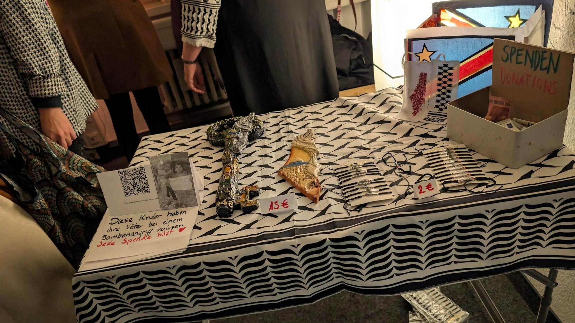 Marktstand: Spendenaufruf, palästinensischer Schlüssel, der die Hoffnung auf Rückkehr symbolisiert und Armbänder.