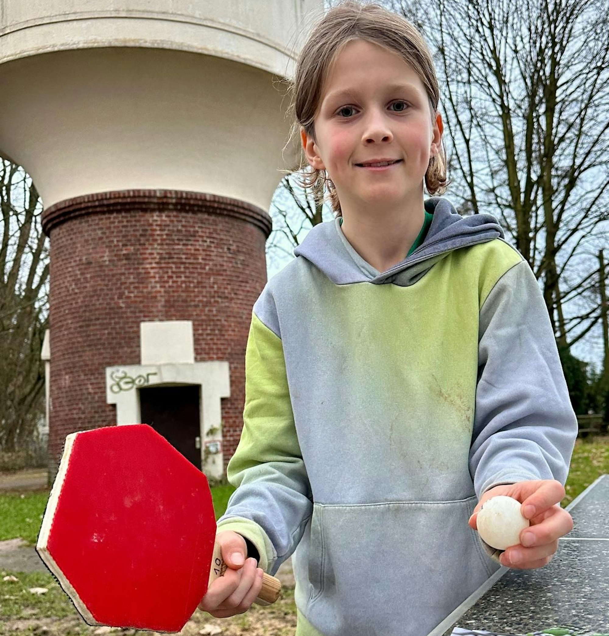 Béla Spiegelhoff posiert mit einem Tischtennisschläger an der neuen Platte.