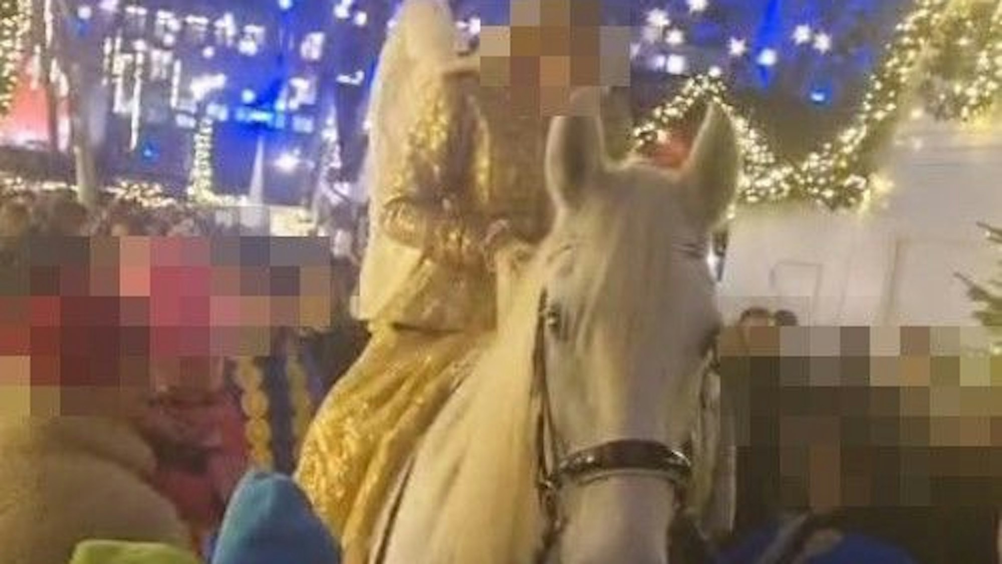 Ein weißes Pferd mit einem Engel darauf auf einem Weihnachtsmarkt.