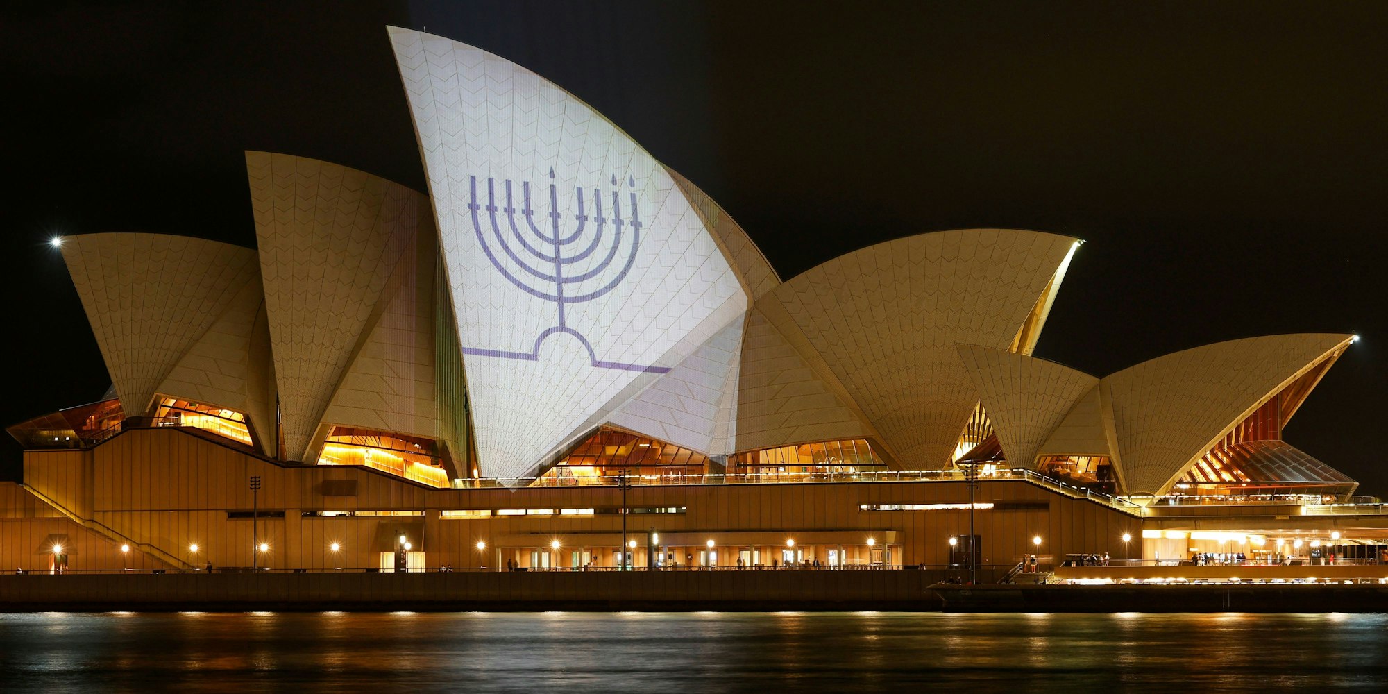 Die Segel des Opernhauses von Sydney sind in Gedenken an die Getöteten am Bondi Beach mit Kerzen auf einer Menora beleuchtet.
