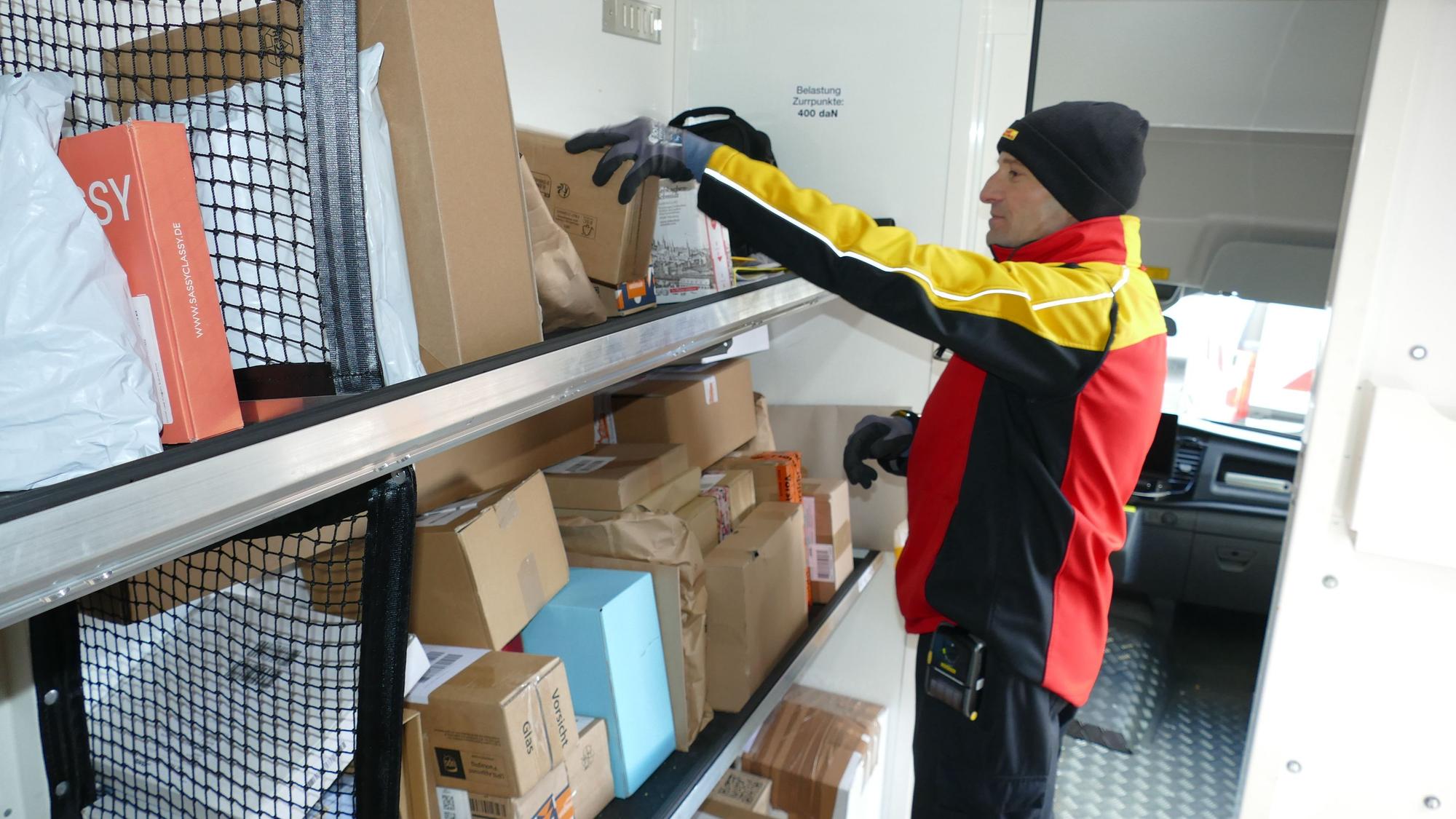 Naser Shkelzeni in seinem elektrisch betriebenen Zustellerfahrzeug: Bis zu 270 Pakete am Tag muss er vor Weihnachten ausliefern.