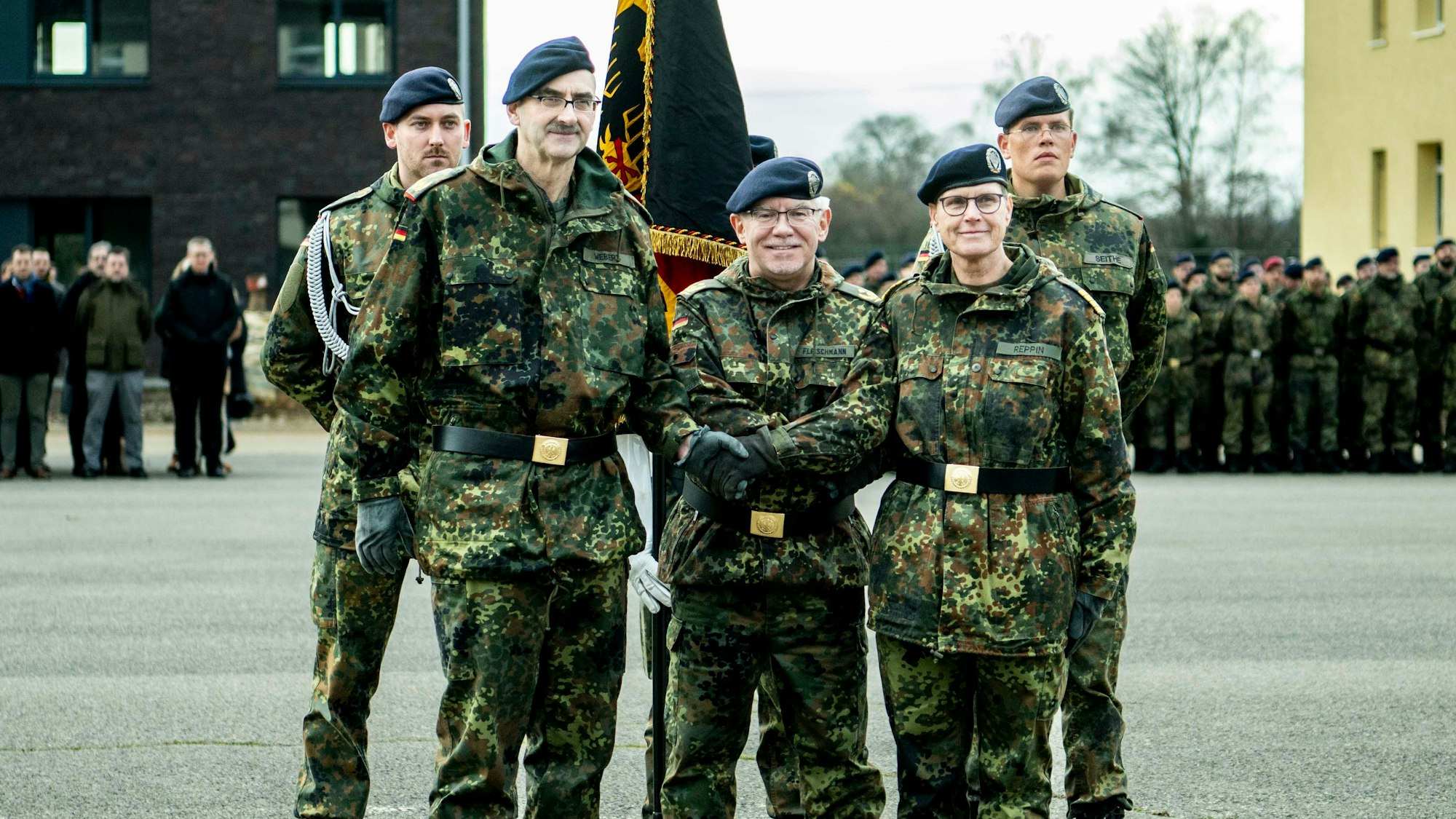 Fünf Soldaten in Flecktarn stehen vor eine Deutschland-Flagge.