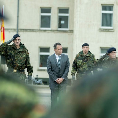 Drei Bundeswehrsoldaten und ein Zivilist stehen in einer Reihe auf dem Hof der Kaserne in Euskirchen.