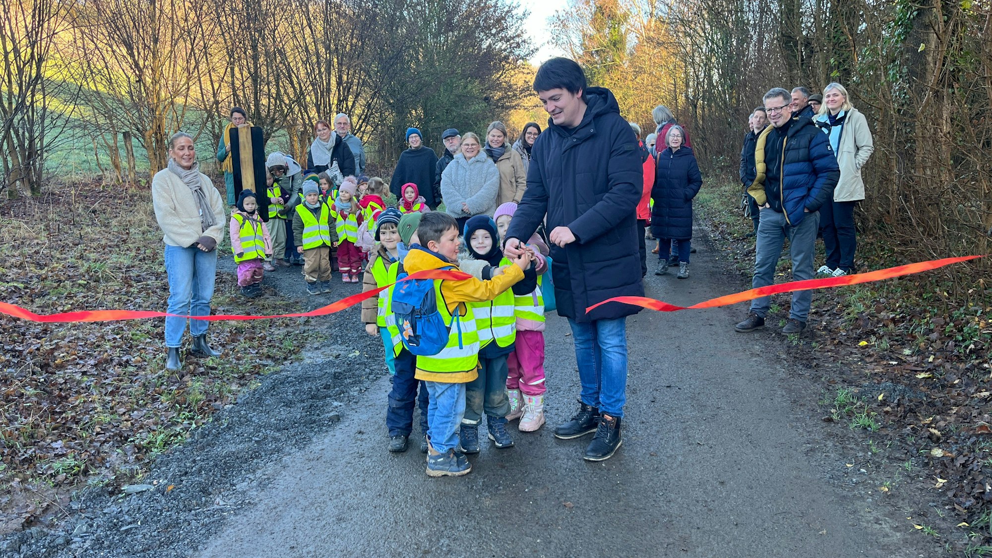 Bürgermeister Mario Dahm schnitt mit den Kindern aus der Kita Vogelnest in Edgoven das rote Band durch.