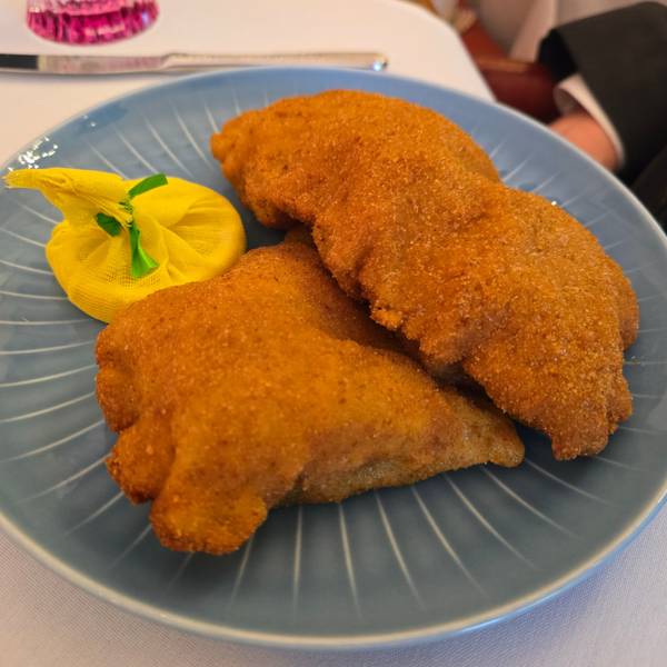 Zwei Wiener Schnitzel liegen auf einem Teller.