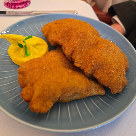 Zwei Wiener Schnitzel liegen auf einem Teller.