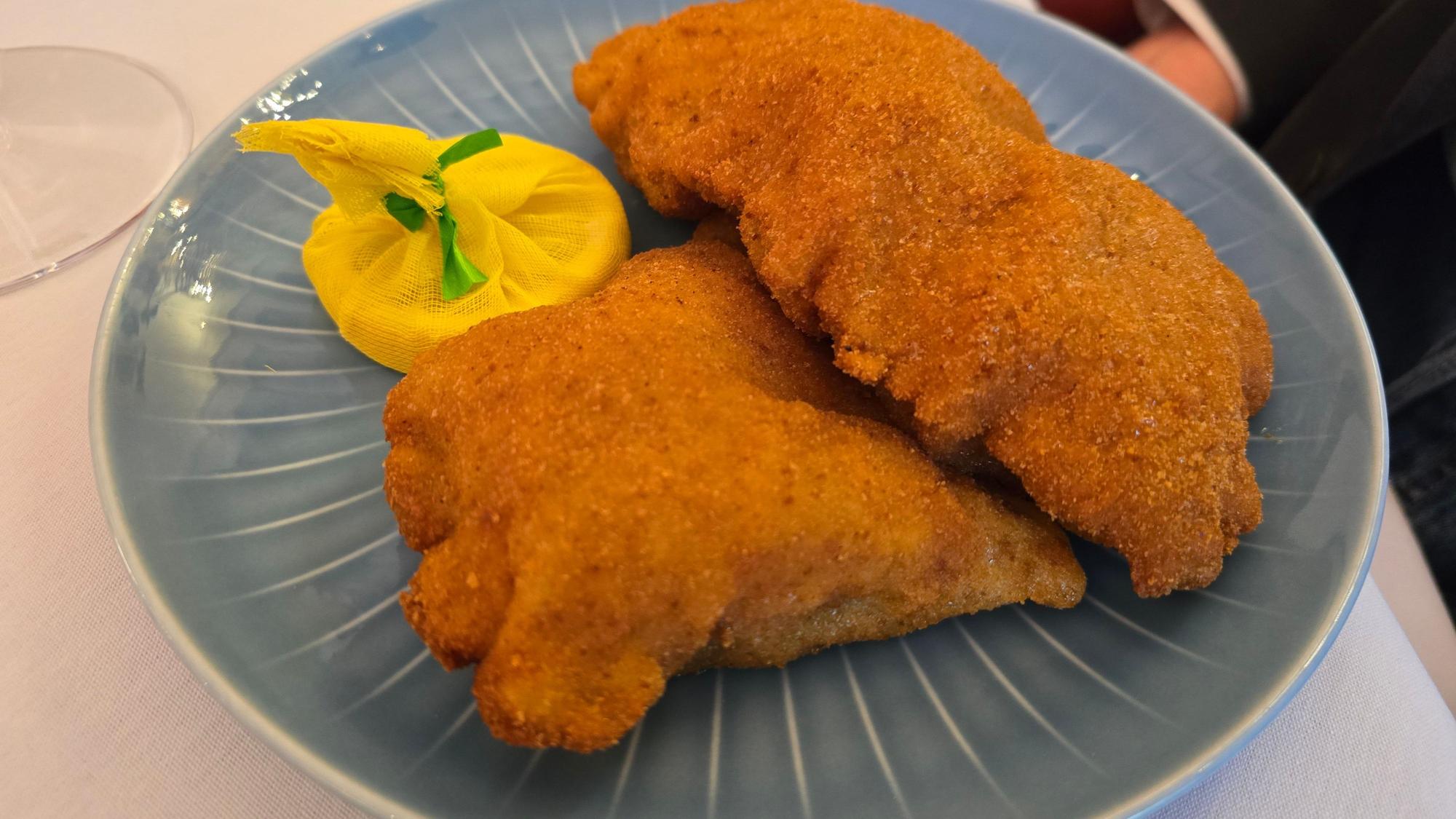 Zwei Wiener Schnitzel liegen auf einem Teller.