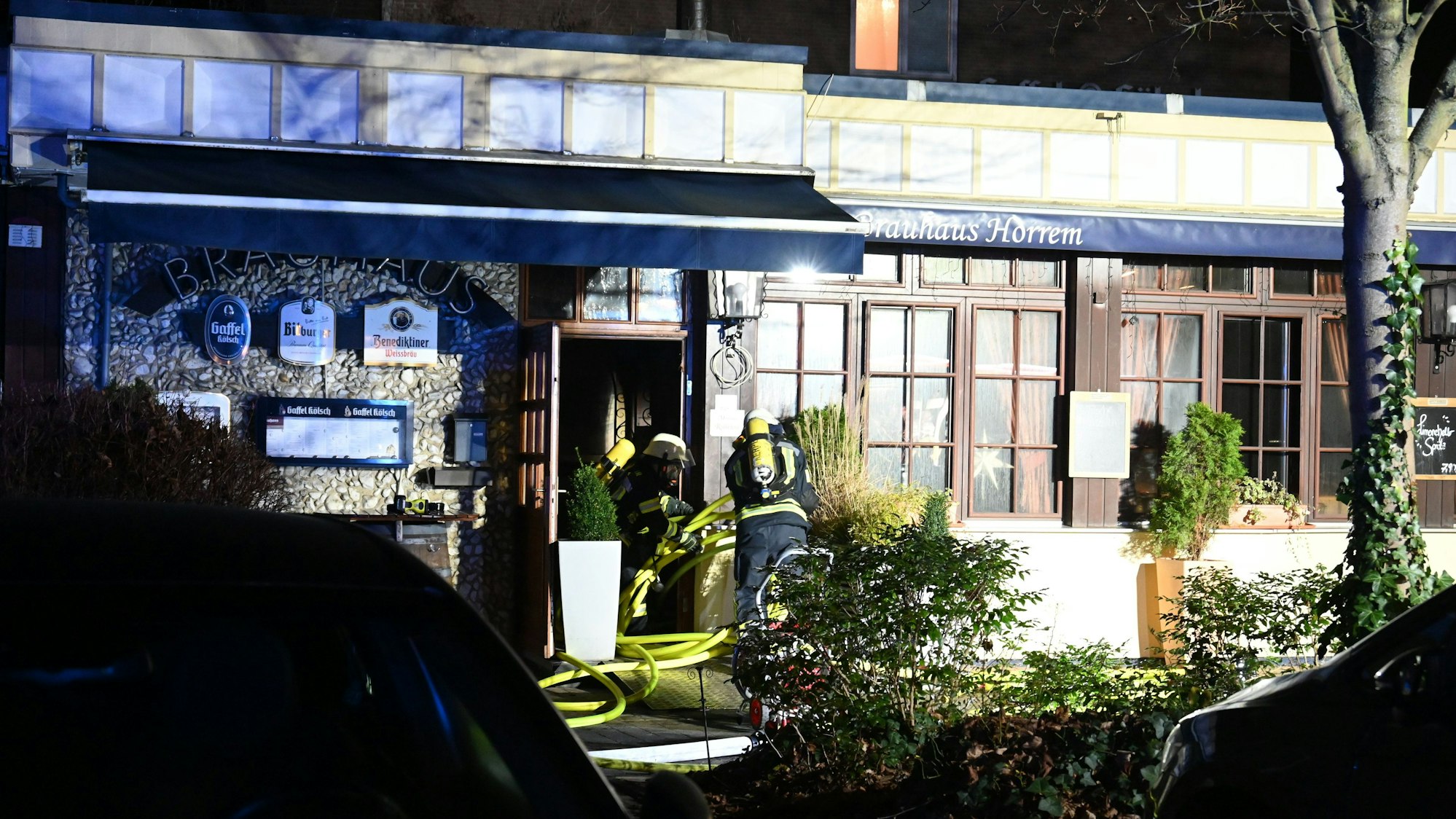 Das Bild zeigt Feuerwehrleute vor der Gaststätte.