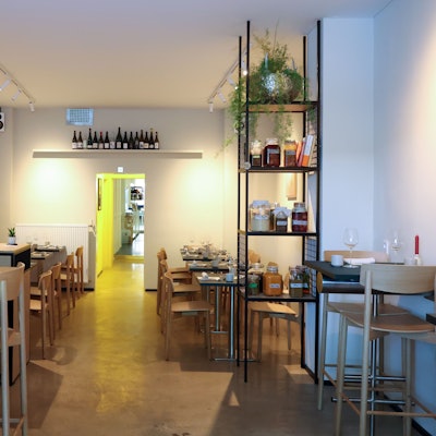 Ein Gastraum mit hellen Holztischen und skandinavischem Look.