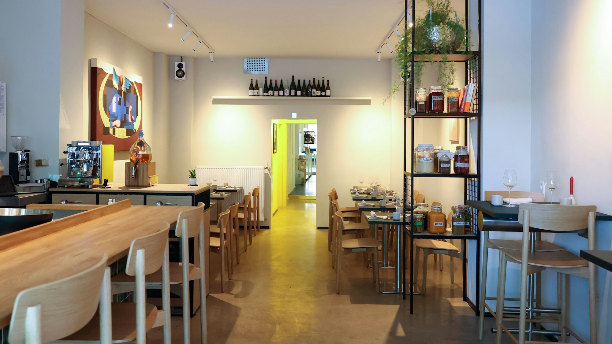 Ein Gastraum mit hellen Holztischen und skandinavischem Look.