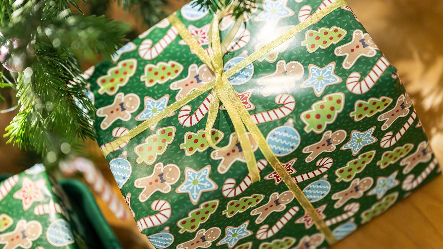 Geschenke liegen unter einem Christbaum in einer Wohnung.