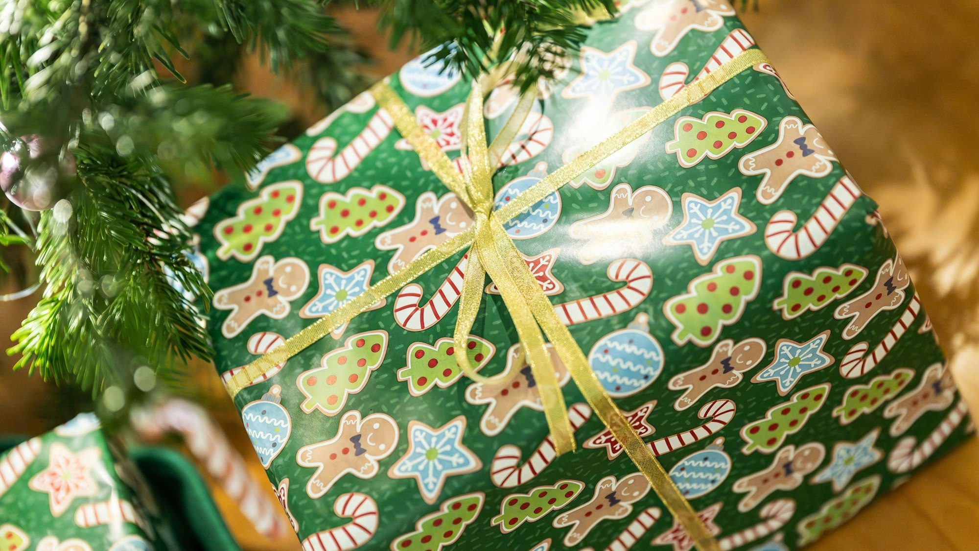 Geschenke liegen unter einem Christbaum in einer Wohnung.