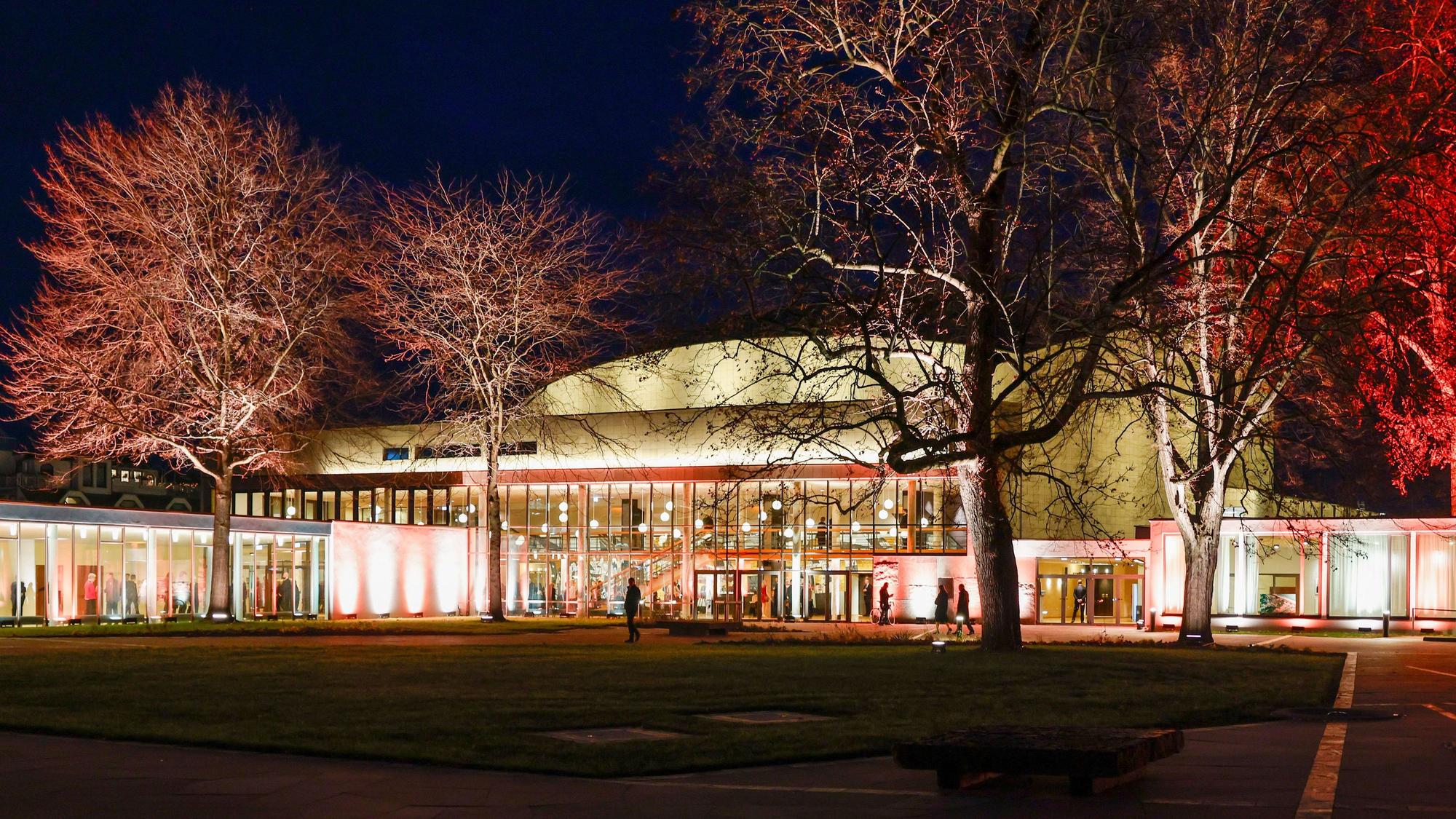 Die wiedereröffnete und farbig beleuchtete Beethovenhalle Bonn von außen.