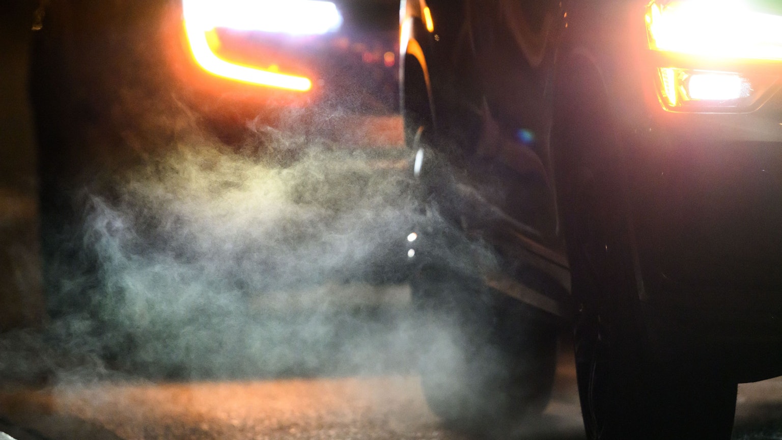 Abgase strömen am Morgen aus den Auspuffen von Verbrenner-Fahrzeugen.