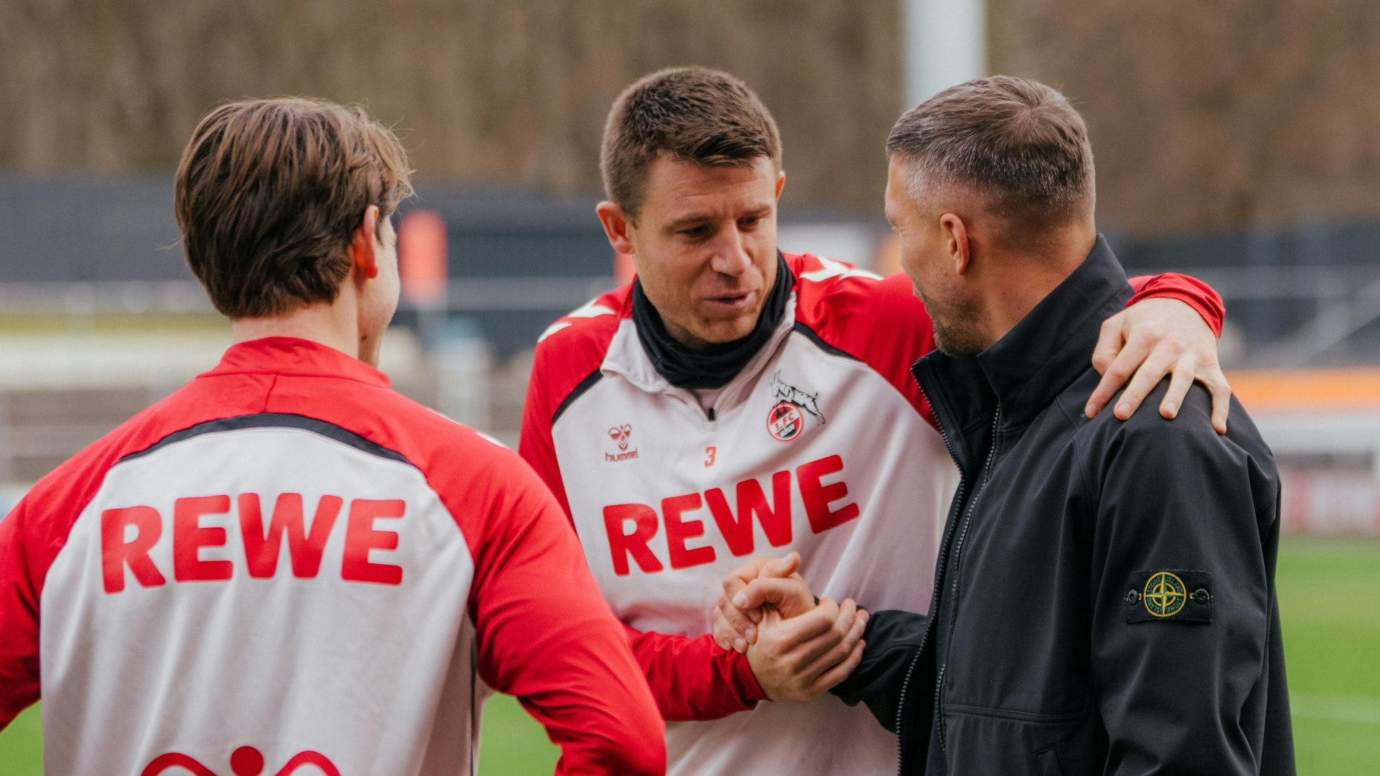 18.12.2025: Lukas Podolski (r.) besucht den 1. FC Köln, hier mit Dominique Heintz (M.) und Jakub Kaminski